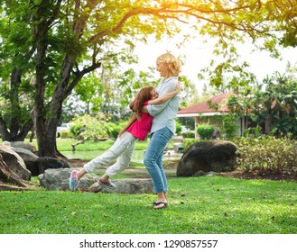 Happy grandmother and granddaughter playing in summer day, Family relaxing in the garden