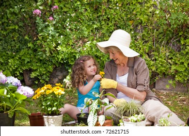 Happy Grandmother with her granddaughter working in the garden - Powered by Shutterstock