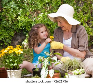 Happy Grandmother with her granddaughter working in the garden - Powered by Shutterstock