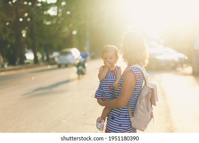 Happy Grandmother Lifting Up Her Little Granddaughter And Hugging In Garden At Sunny Day Outdoors. Beautiful Middle Aged Woman And Cute Small Girl. Travel With Toddler. Mother's Family Day Concept 