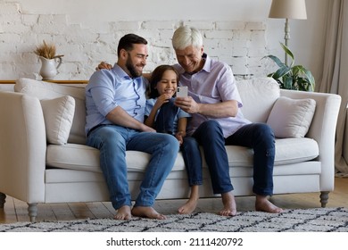 Happy Grandpa, Father And Gen Z Kid Boy Making Video Call On Smartphone Together, Talking, Smiling At Screen, Resting On Couch, Sharing Mobile Phone, Taking Selfie, Laughing, Enjoying Leisure Time