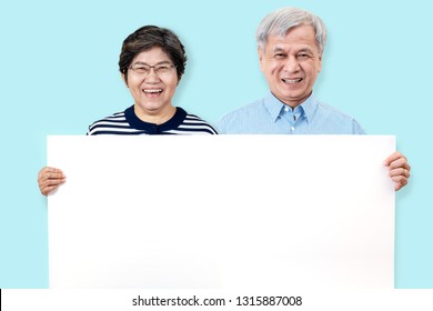 Happy grandpa and grandma smiling with white teeth, enjoy moment and holding a blank board. Asian grandparents showing white blank board for your advertising text message or promotional content. - Powered by Shutterstock