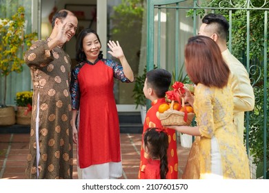 Happy grandparents greeting their children and grandchildren who came for Lunar New Year celebration at house entrance - Shutterstock ID 2107601570