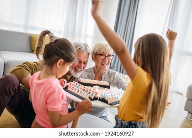 Happy grandparents having fun times with children at home