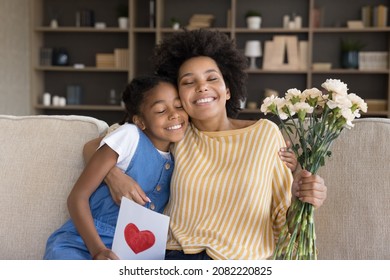 Happy Grateful Black Mom Hugging Daughter Kid With Love, Tenderness, Receiving Bunch Of Flowers, Handmade Greeting Card Due To Mothers Day, Birthday, 8 March. Motherhood, Family Concept