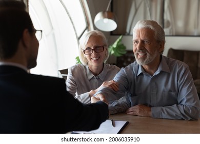 Happy Grateful Elderly Couple Of Clients Thanking Real Estate Agent, Lawyer, Broker For Help With House Buying Or Selling, Medical Treatment Contract, Insurance Agreement Signing, Giving Handshake