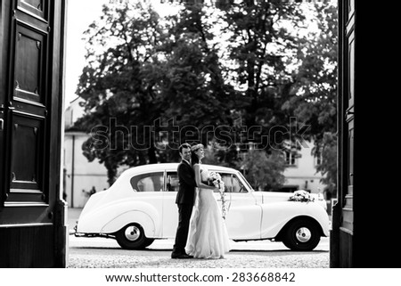 happy groom and bride on the background old fashion car