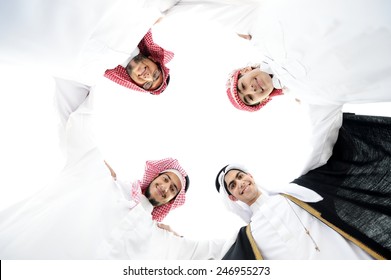 Happy Group Of Arabic People With Heads Together In Circle Over Sky Background