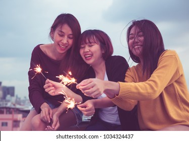 Happy Group Of Asia Girl Friends Enjoy And Play Sparkler At Roof Top Party At Evening Sunset,Holiday Celebration Festive,teenage Lifestyle,freedom And Fun