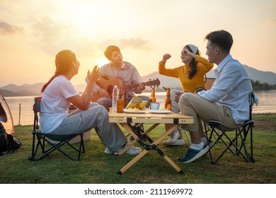 Happy Group Of Asian Friends Play Guitar And Sing Enjoying Camping And Drinking Beer