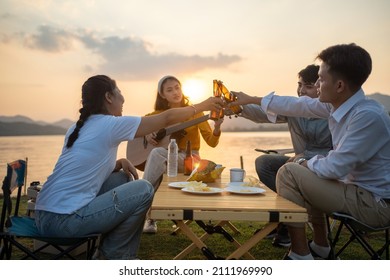 Happy Group Of Asian Friends Play Guitar And Sing Enjoying Camping And Drinking Beer