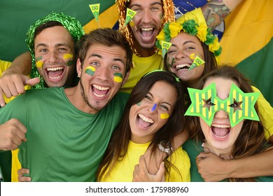 Happy group of Brazilian sport soccer fans amazed celebrating victory together.