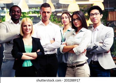 Happy Group Of Co-workers With Arms Folded Standing In Office