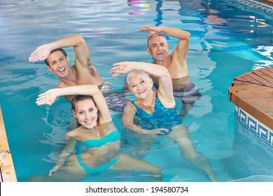 Happy Group Doing Aqua Fitness Class In A Swimming Pool