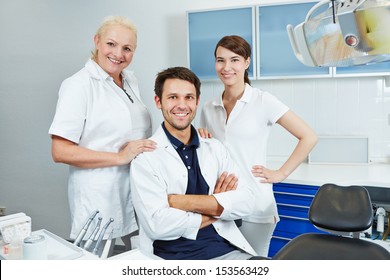 Happy group of employees at dentist with two dental assistants