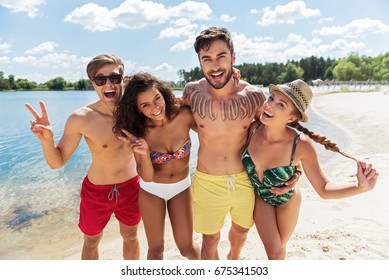 Happy Group Of Four Friends Resting On Summer Beach