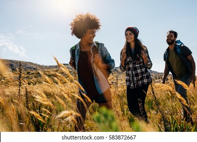 Happy Group Of Friends Hiking Together On A Summer Day. Group Of Friends On Walk Through Countryside.