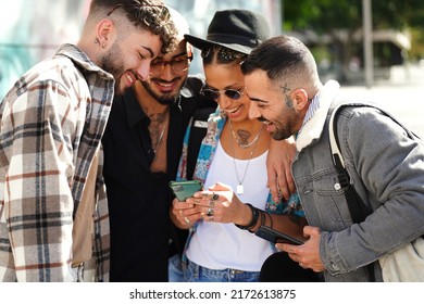 Happy Group Of Friends Watching Social Media On Screen Mobile Phone, Laughing. Young People Using Smartphone, Having Fun Together In The City. Tourists. Traveler.
                