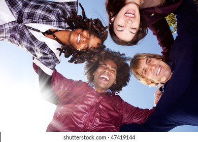 A happy group hug of friends - with solar flare from bottom left - Powered by Shutterstock