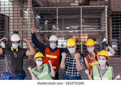 Happy group of industrial worker wearing protective face mask celebrating after factory reopen at construction site. success business teamwork corporate industry people. new normal working concept