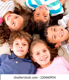 Happy group of kids lying on the floor with heads together