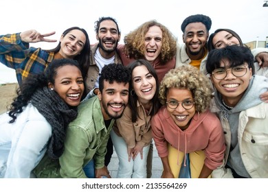 Happy group of multiethnic young friends - Diverse people smiling at camera outdoors - Community and unity people concept - Shutterstock ID 2135564269