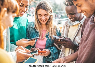 Happy group of multiracial teens using smart mobile phone outdoors - Diverse university students watching smartphones in college campus - Millenial people having fun on city street - Youth culture  - Powered by Shutterstock