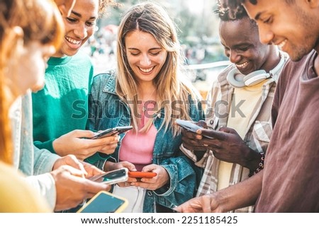 Happy group of multiracial teens using smart mobile phone outdoors - Diverse university students watching smartphones in college campus - Millenial people having fun on city street - Youth culture 