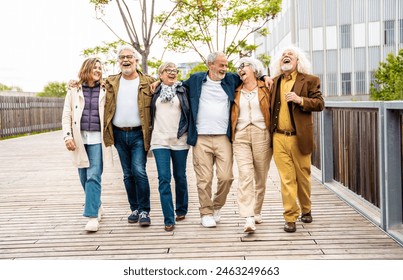 Happy group of senior people walking outdoors - Laughing aged friends having fun on city street  - Powered by Shutterstock