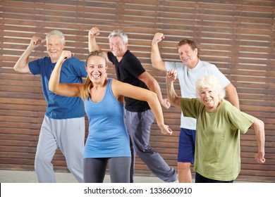 Happy group of seniors dancing together in the fitness center