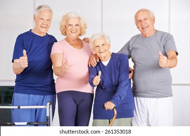 Happy group of seniors holding thumbs up in a nursing home