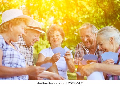 Happy Group Of Seniors Together While Playing Cards In Summer