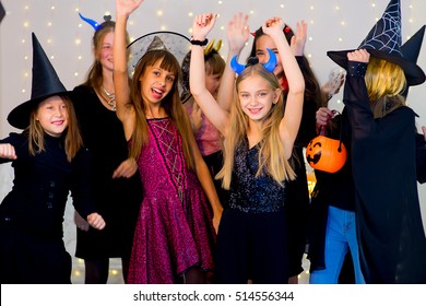 Happy Group Of Teenagers Dance In Halloween Costumes During The Halloween Party With Pumpkins