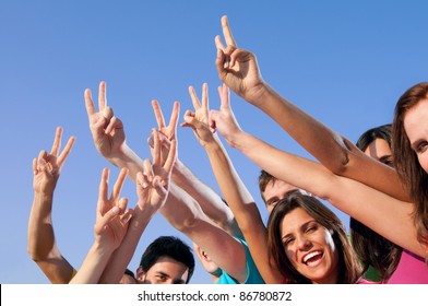 Happy Group Of Young Friends Showing Victory Hand Sign Over Blue Sky