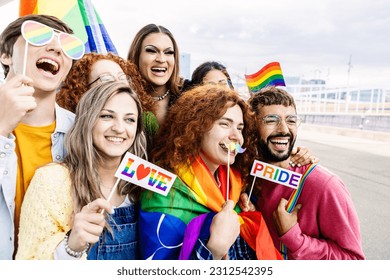 Happy group of young people celebrating gay pride day festival together. Millennial homosexual adult friends enjoying celebration about equal rights and freedom - Powered by Shutterstock