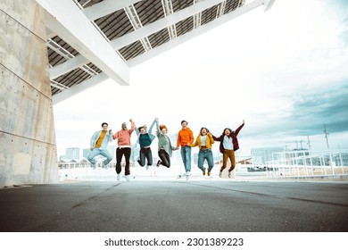 Happy group of young people jumping on city street - Multiracial students college celebrating outside - Life style concept with guys and girls having fun together hanging outside - Shutterstock ID 2301389223