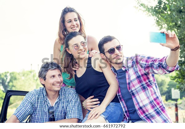 Happy group of young people takes a selfie\
outdoor in the summertime