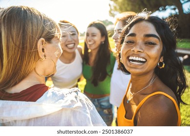 Happy group of young women hugging together outside - Cheerful black girl smiling at camera outdoors - Friendship and female community concept with multicultural girls having fun hanging out together - Powered by Shutterstock