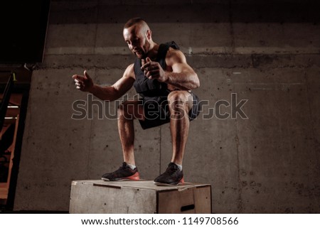 happy guy at the gym working out standing on a wooden squat box.strength training.