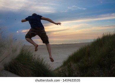 Happy guy jumping from the dune