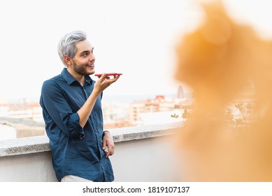 Happy Guy Talking Over Smart Phone Using Voice Notes Outdoors - Focus On Face