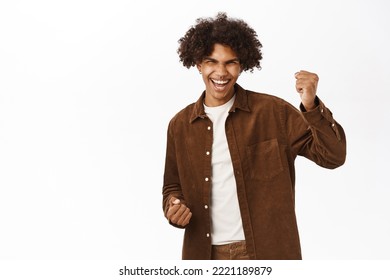 Happy Guy Triumphing And Celebrating, Saying Yes With Ecstatic Face Emotion, Standing Over White Background