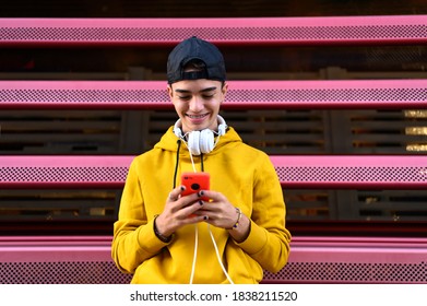 Happy guy using a smart phone to listen music with headphones