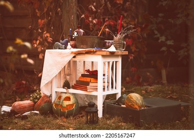 Happy Halloween Carving Pumpkin On The Table In The Garden. Happy Family Preparing For Halloween. Background Photo