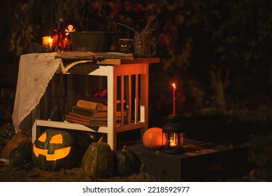 Happy Halloween Carving Pumpkin On The Table In The Garden. Happy Family Preparing For Halloween. Background Photo