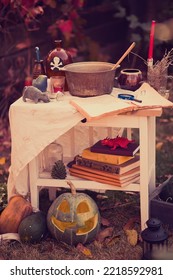 Happy Halloween Carving Pumpkin On The Table In The Garden. Happy Family Preparing For Halloween. Background Photo