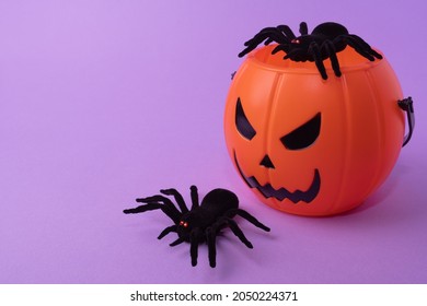 Happy Halloween concept. Halloween pumpkin bucket with black spiders on a purple background. plastic candy bucket Trick Or Treat - Powered by Shutterstock