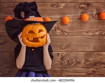 Happy Halloween! Cute Little Witch With A Pumpkin.