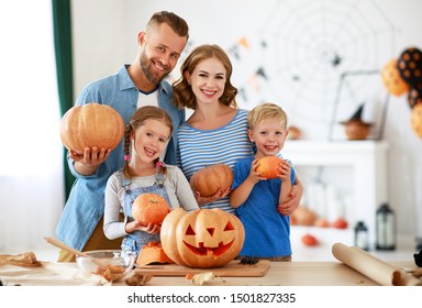 Happy Halloween! Family Mother Father And Children Cut A Pumpkin For Holiday At Home