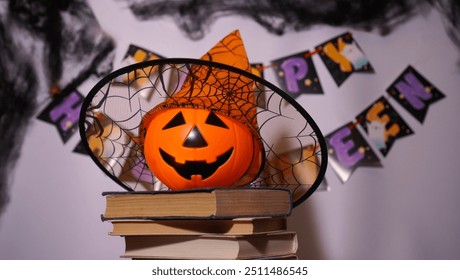 Happy Halloween greeting card with orange basket with smiling Jack face and hat on head standing on stack of old books with free space to insert text - Powered by Shutterstock